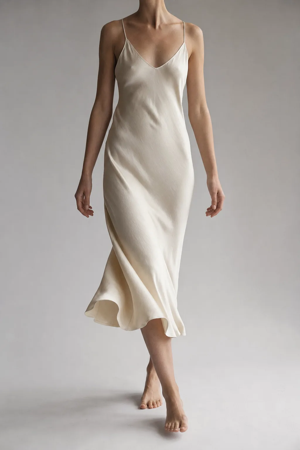 The hem of the ines dress mid-step, dead-stock silk swinging above bare feet
